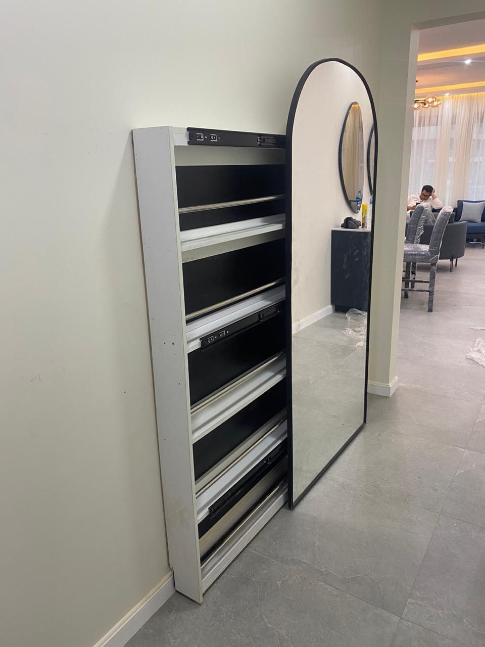 A shoe cabinet with a mirror